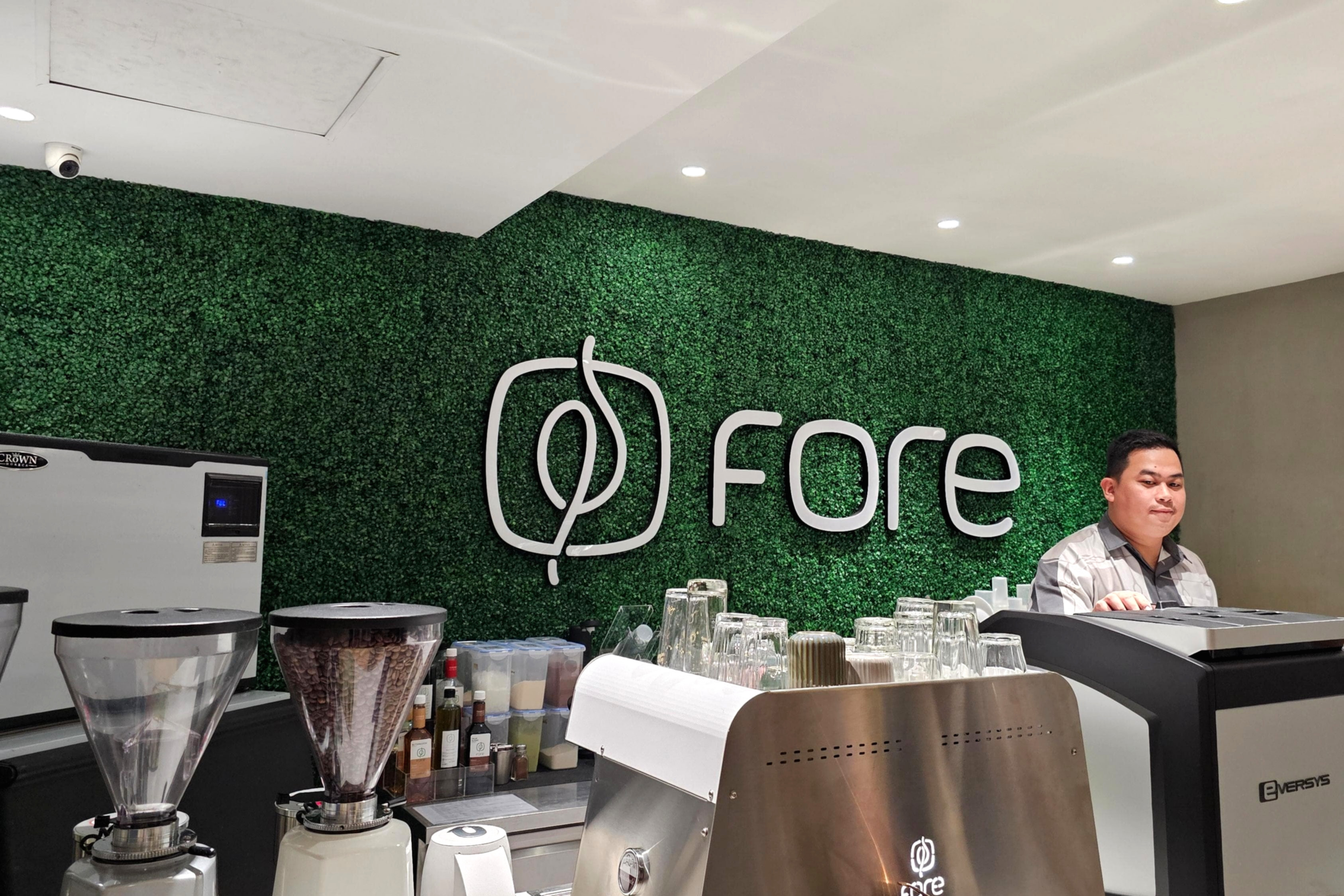 Suasana gerai Fore Coffee dengan logo perusahaan yang terlihat jelas di area perkantoran Jakarta.