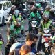 Seorang pengemudi ojek online sedang membawa pesanan makanan dan barang di Jakarta.