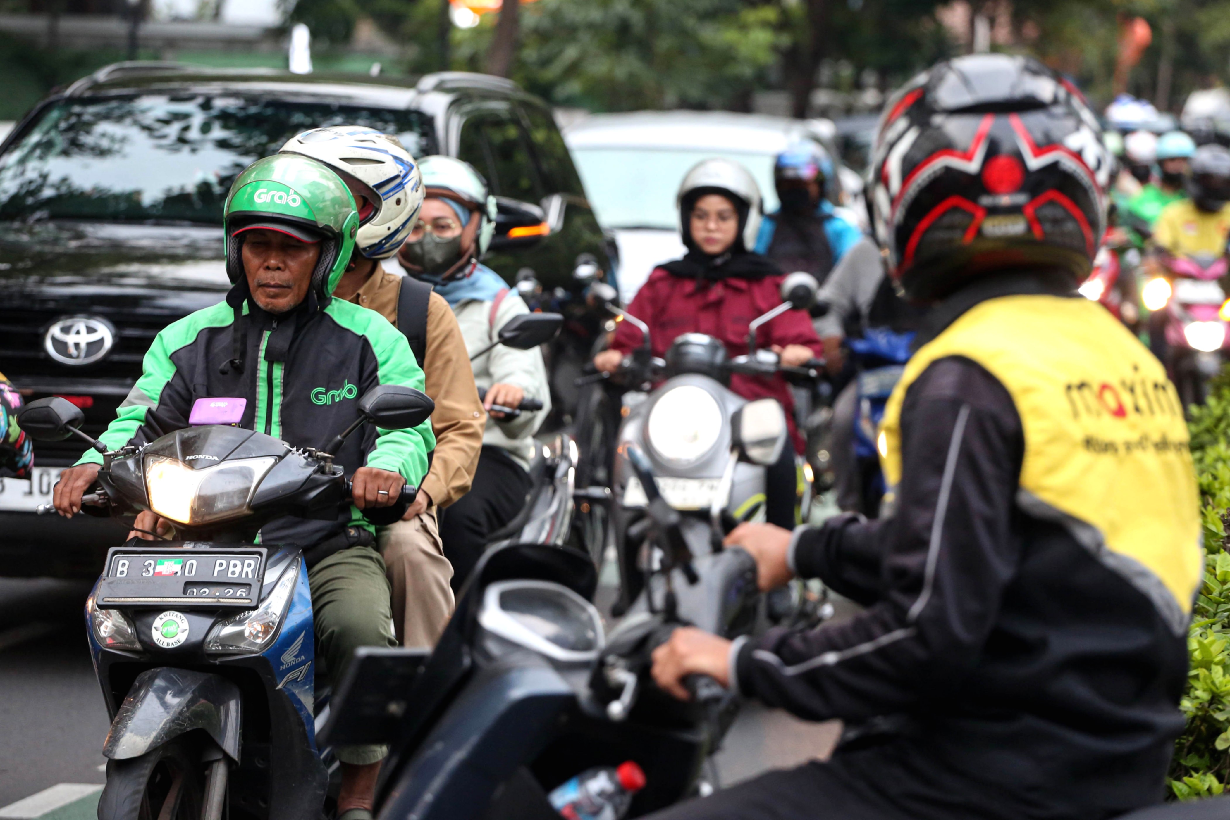 Pengendara ojek online Maxim melintas di jalanan Jakarta untuk melayani pesanan pelanggan.