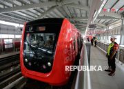 Kereta LRT Jakarta melintas di jalur rel dengan latar belakang gedung perkotaan