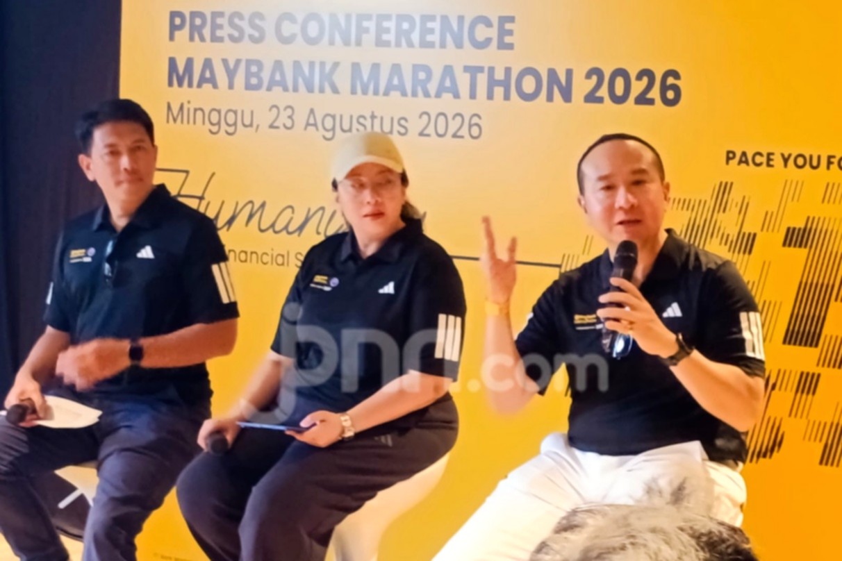 Pelari mengikuti ajang Maybank Marathon di jalanan Bali dengan latar belakang pemandangan khas daerah Gianyar.