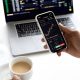 Seorang pengguna menggunakan aplikasi investasi saham di ponsel pintar untuk memantau portofolio keuangan