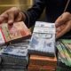 Papan layar elektronik menampilkan pergerakan nilai tukar mata uang rupiah terhadap dolar AS di Jakarta.