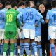 Logo Manchester City di Stadion Etihad dengan latar belakang lapangan hijau