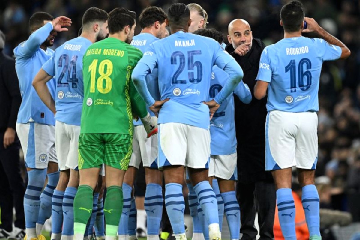 Logo Manchester City di Stadion Etihad dengan latar belakang lapangan hijau