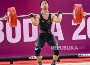 Atlet angkat besi Rahmat Erwin Abdullah merayakan kemenangan setelah meraih medali emas di Asian Games 2026.