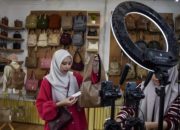 Tampilan antarmuka aplikasi marketplace di layar ponsel pintar dengan latar belakang perkantoran